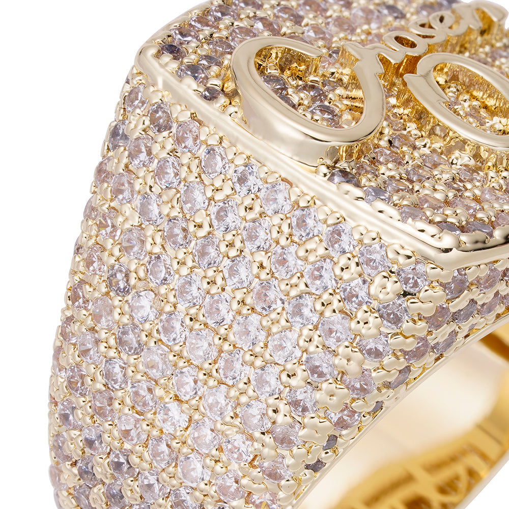 Close-up detail of iced out pavΓ© cubic zirconia coverage and gold OO logo on ring