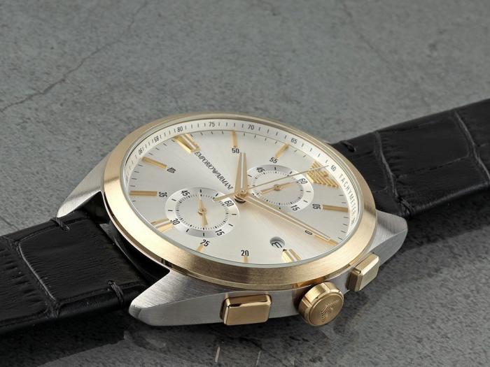 Emporio Armani Claudio chronograph on wrist showing white dial with gold accents and black leather strap