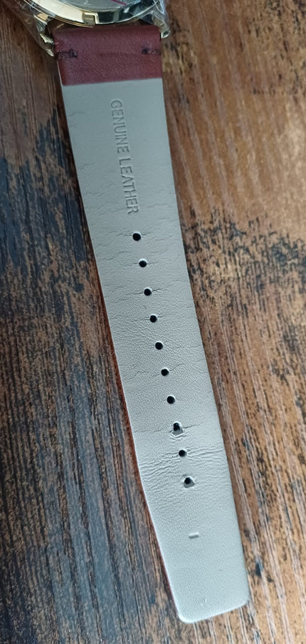Watch strap interior showing white fabric with punched holes and brand text