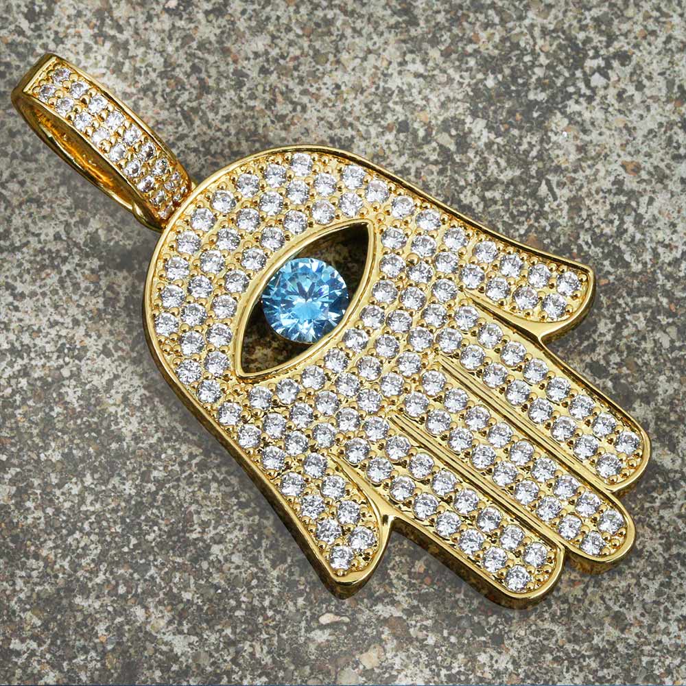 Iced out hamsa pendant on textured surface showing three-dimensional depth and crystal detail