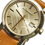 ساعة بربري ذا سيتي النسائية، مينا بلون الشمبانيا، جلد بني فاتح وحواف من القماش، موديل BU9133