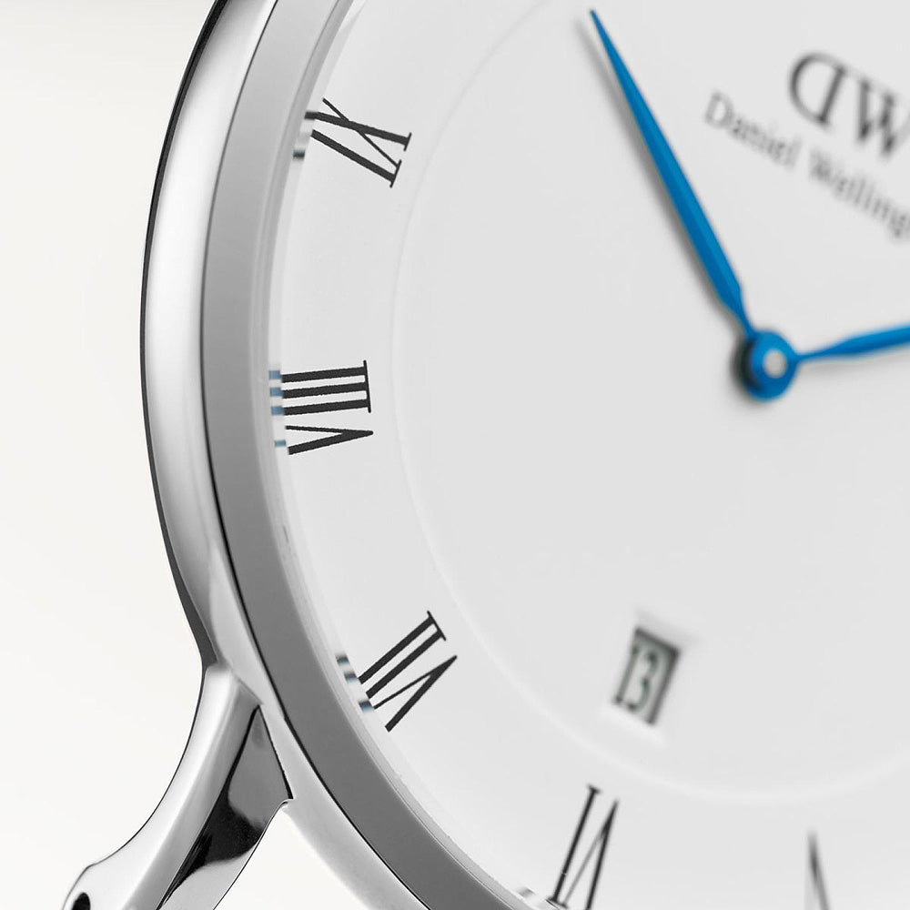 Close-up of Dapper York white dial featuring Roman numerals, blue hands, and date window at 6 o'clock