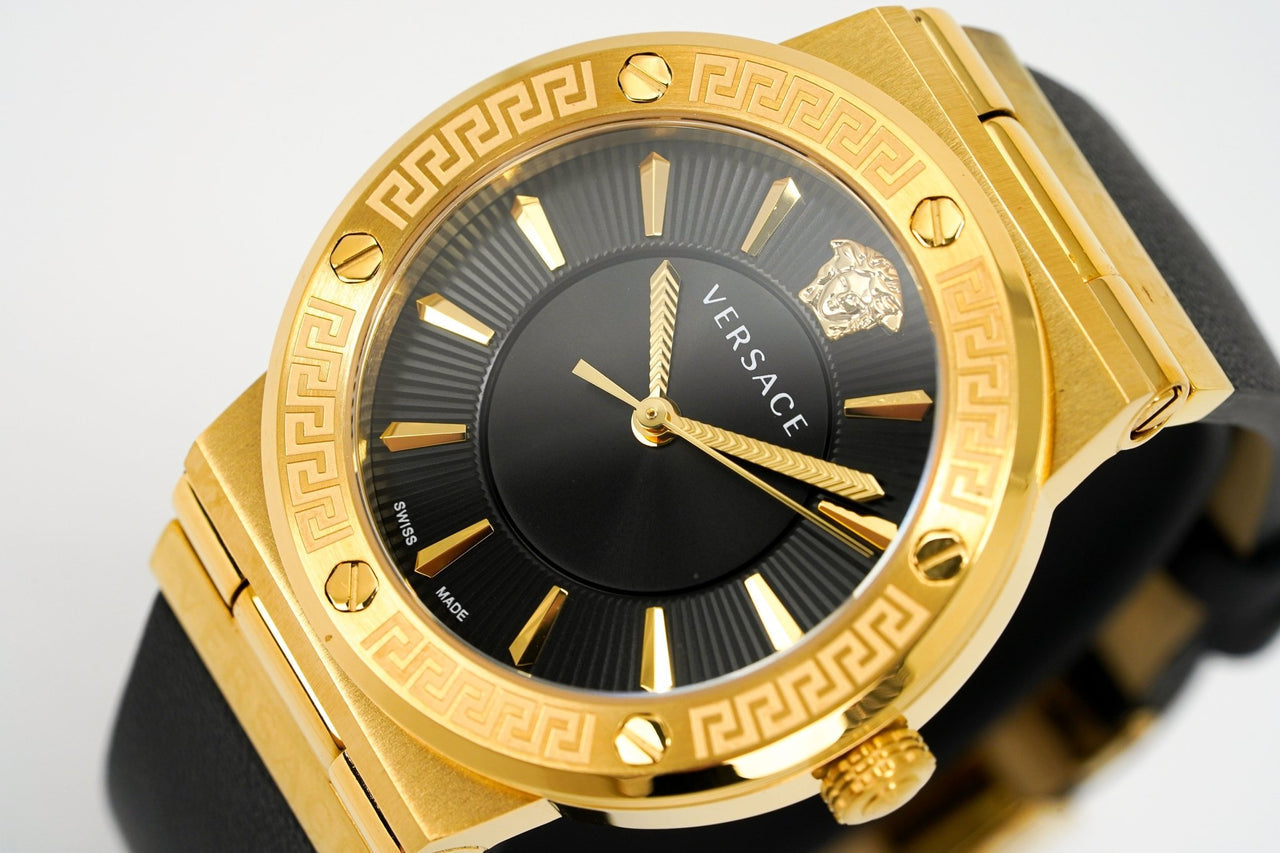 Angled view of Versace Greca watch showing gold case with Greek key pattern and black dial